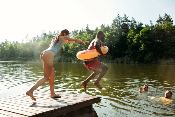 Szczęśliwych przyjaciół zabawy, skoki i pływanie w rzece — Zdjęcie stockowe