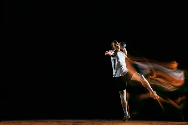 Молодой гандболист на фоне темных студий в смешанном свете — стоковое фото