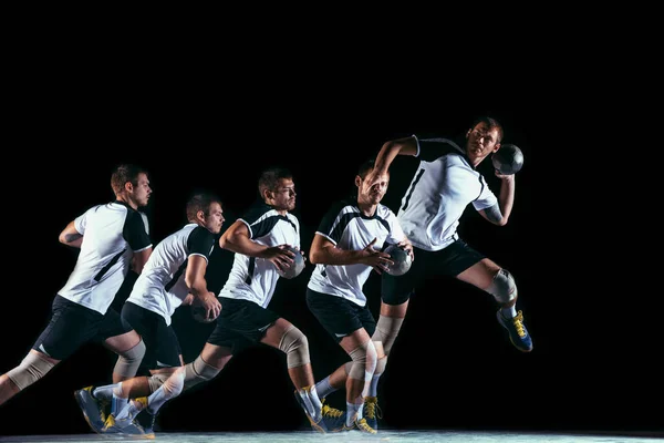 Young handball player against dark studio background in strobe light — Stock Photo, Image