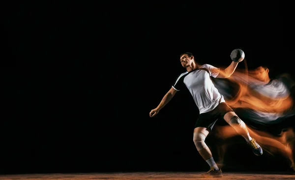 Young handball player against dark studio background in mixed light Stock Image