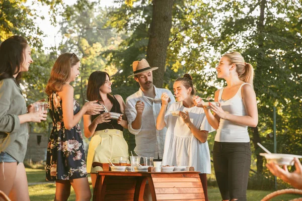 Happy Friends jedzenia i picia piwa na obiad Grill na zachodzie słońca — Zdjęcie stockowe