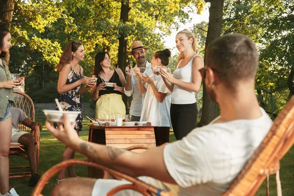 Happy Friends jedzenia i picia piwa na obiad Grill na zachodzie słońca — Zdjęcie stockowe