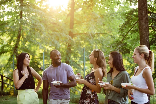 Happy friends eating and drinking beers at barbecue dinner on sunset time — Stock Photo, Image