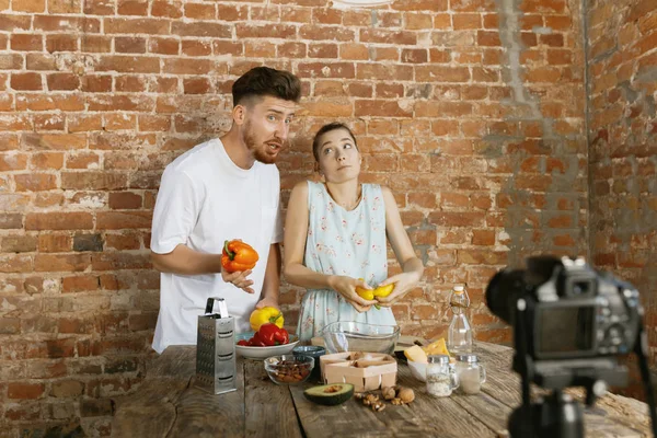 Pareja joven cocinando y grabando video en vivo para vlog y redes sociales — Foto de Stock