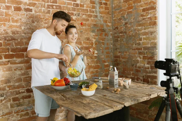 Young couple cooking and recording live video for vlog and social media