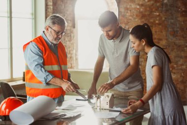 Foreman veya achitect genç bir çift için ev, ofis veya mağaza tasarım planları gösterir