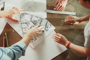 Foreman veya achitect genç bir çift için ev, ofis veya mağaza tasarım planları gösterir