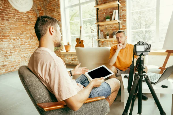 Deux jeunes blogueurs avec caméra professionnelle enregistrant une interview vidéo à la maison — Photo