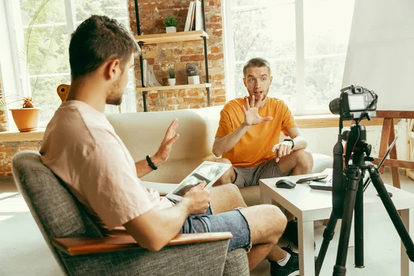 Deux jeunes blogueurs avec caméra professionnelle enregistrant une interview vidéo à la maison — Photo