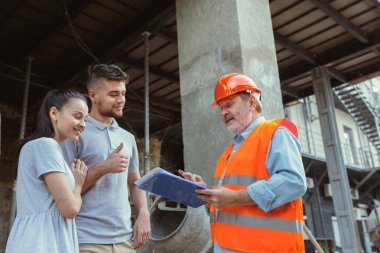 Foreman veya achitect genç bir çift için ev, ofis veya mağaza tasarım planları gösterir