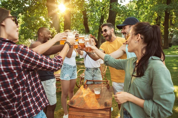 Amici felici stanno avendo birra e barbecue party nella giornata di sole — Foto Stock