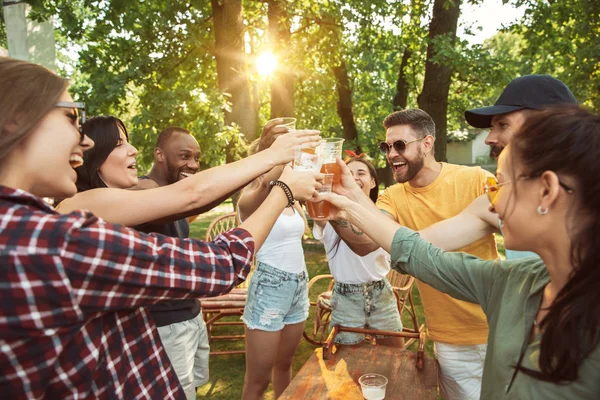 Amigos felices dan una fiesta de cerveza y barbacoa en un día soleado — Foto de Stock