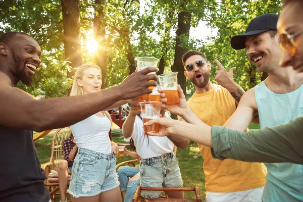 Счастливые друзья устраивают барбекю и пиво в солнечный день — стоковое фото