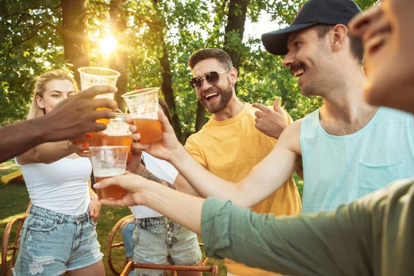 Happy friends are having beer and barbecue party at sunny day — Stock Photo, Image