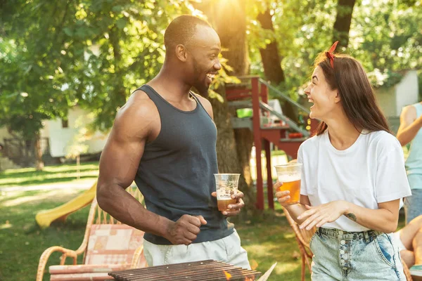 Amigos felices dan una fiesta de cerveza y barbacoa en un día soleado — Foto de Stock