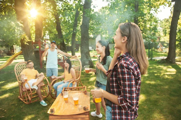 Happy friends are having beer and barbecue party at sunny day — Stock Photo, Image