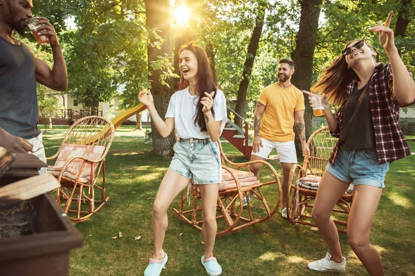 Happy friends are having beer and barbecue party at sunny day — Stock Photo, Image