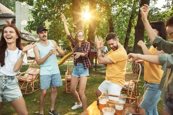 Amigos felices dan una fiesta de cerveza y barbacoa en un día soleado — Foto de Stock