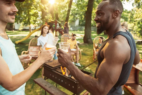 Amigos felices dan una fiesta de cerveza y barbacoa en un día soleado — Foto de Stock