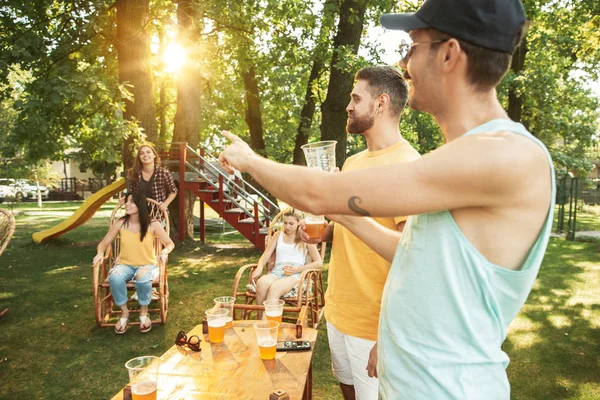 Happy friends are having beer and barbecue party at sunny day — Stock Photo, Image