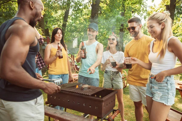 Amigos felices dan una fiesta de cerveza y barbacoa en un día soleado — Foto de Stock