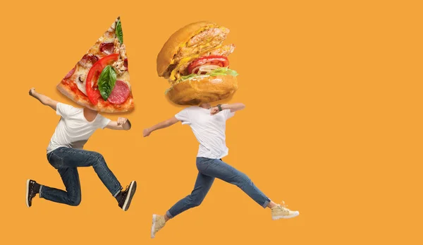 Концепция быстрого питания. Молодые люди бегают на оранжевом фоне — стоковое фото