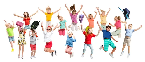 Groep basisschool kinderen springen, terug naar school — Stockfoto