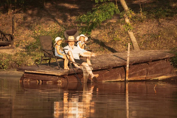 Lindas niñas y su abuelo están en la pesca en el lago o el río —  Fotos de Stock