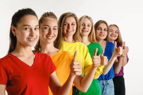 Mulheres jovens vestidas em cores de bandeira LGBT isoladas em fundo branco, conceito de orgulho LGBT — Fotografia de Stock