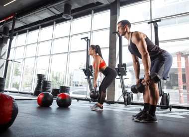 Spor salonunda egzersiz yapan kaslı sporcular