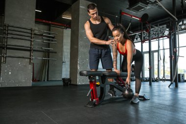 Spor salonunda egzersiz yapan kaslı sporcular