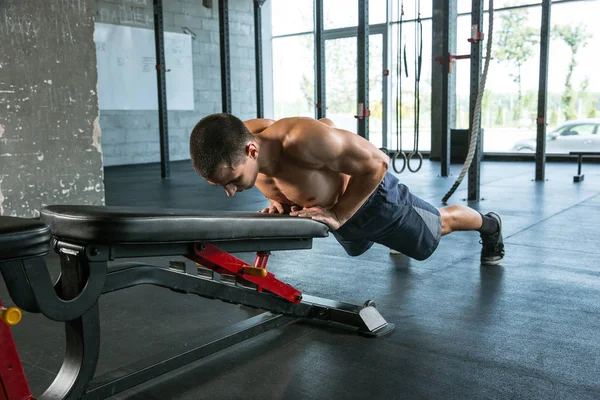 Um atleta masculino musculoso fazendo exercício no ginásio — Fotografia de Stock