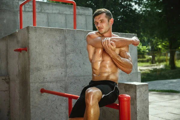 Ung muskulös man medan du gör hans träning utanför på Playground — Stockfoto