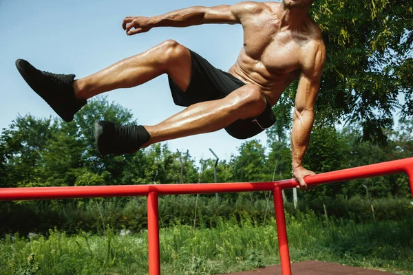 Junger muskulöser Mann beim Training draußen auf dem Spielplatz — Stockfoto