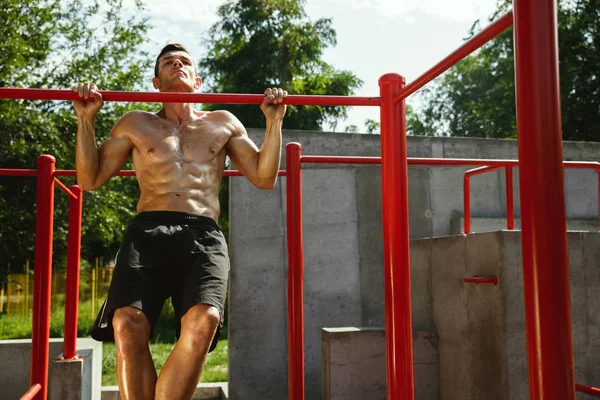 Junger muskulöser Mann beim Training draußen auf dem Spielplatz — Stockfoto