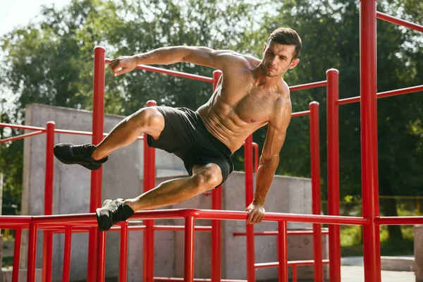 Junger muskulöser Mann beim Training draußen auf dem Spielplatz — Stockfoto