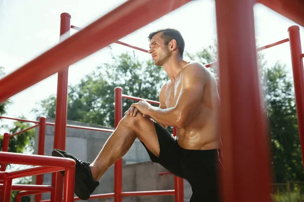 Junger muskulöser Mann beim Training draußen auf dem Spielplatz — Stockfoto