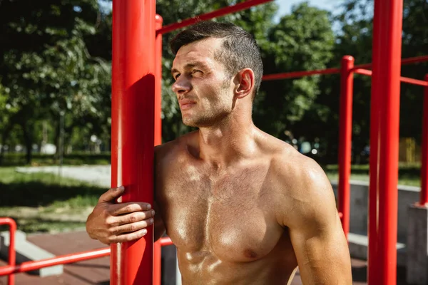 Junger muskulöser Mann beim Training draußen auf dem Spielplatz — Stockfoto