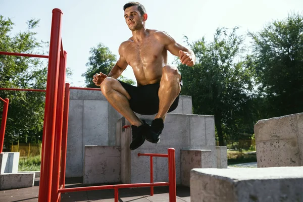 Junger muskulöser Mann beim Training draußen auf dem Spielplatz — Stockfoto