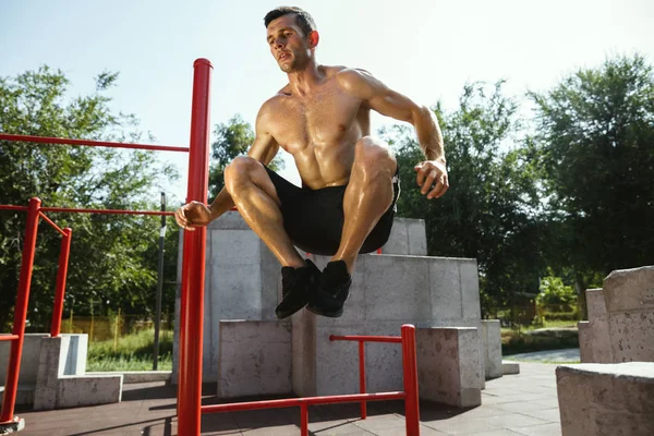 Junger muskulöser Mann beim Training draußen auf dem Spielplatz — Stockfoto