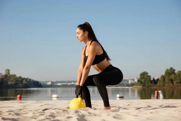 Genç sağlıklı kadın atlet plajda egzersiz yapıyor — Stok fotoğraf