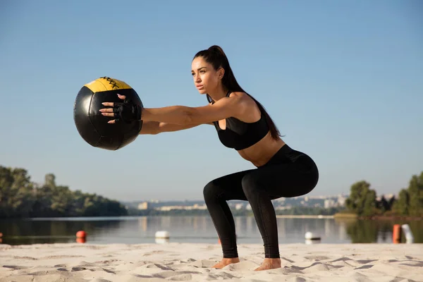 Genç sağlıklı kadın atlet plajda egzersiz yapıyor — Stok fotoğraf