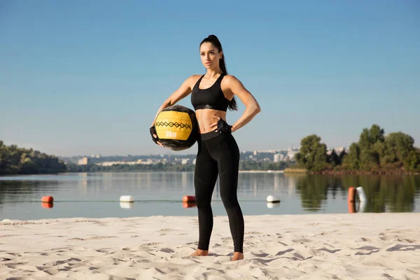 Młoda zdrowa kobieta sportowiec robi trening na plaży — Zdjęcie stockowe