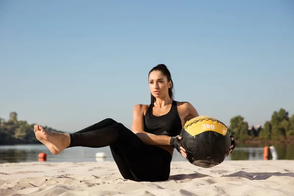 Young healthy female athlete doing workout at the beach — Stock Photo, Image