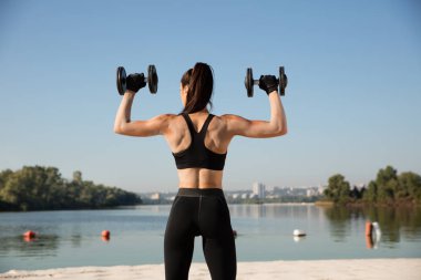 Genç sağlıklı kadın atlet plajda egzersiz yapıyor