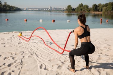 Genç sağlıklı kadın atlet plajda egzersiz yapıyor