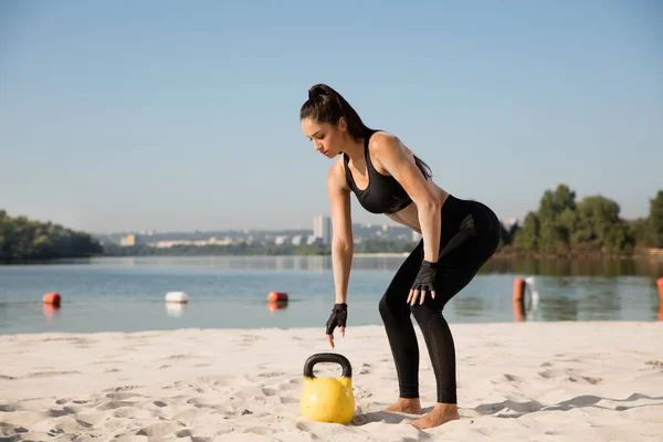 ビーチでワークアウトをしている若い健康な女性アスリート — ストック写真