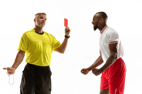 Arbitro di calcio che mostra un cartellino rosso ad un giocatore scontento isolato su sfondo bianco — Foto Stock