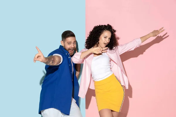 Joven hombre y mujer emocional sobre fondo rosa y azul — Foto de Stock