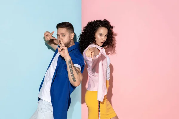 Joven hombre y mujer emocional sobre fondo rosa y azul — Foto de Stock